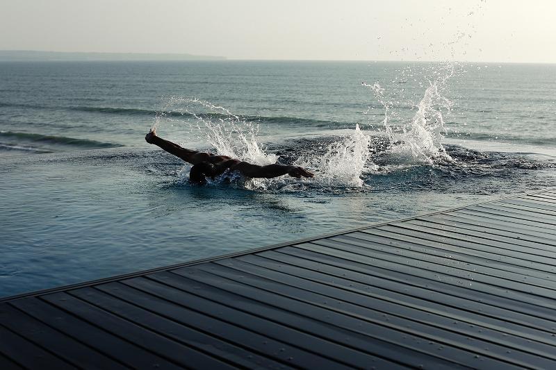 Отель Alila Seminyak Экстерьер фото A swimmer entering the sea at the beach of the resort